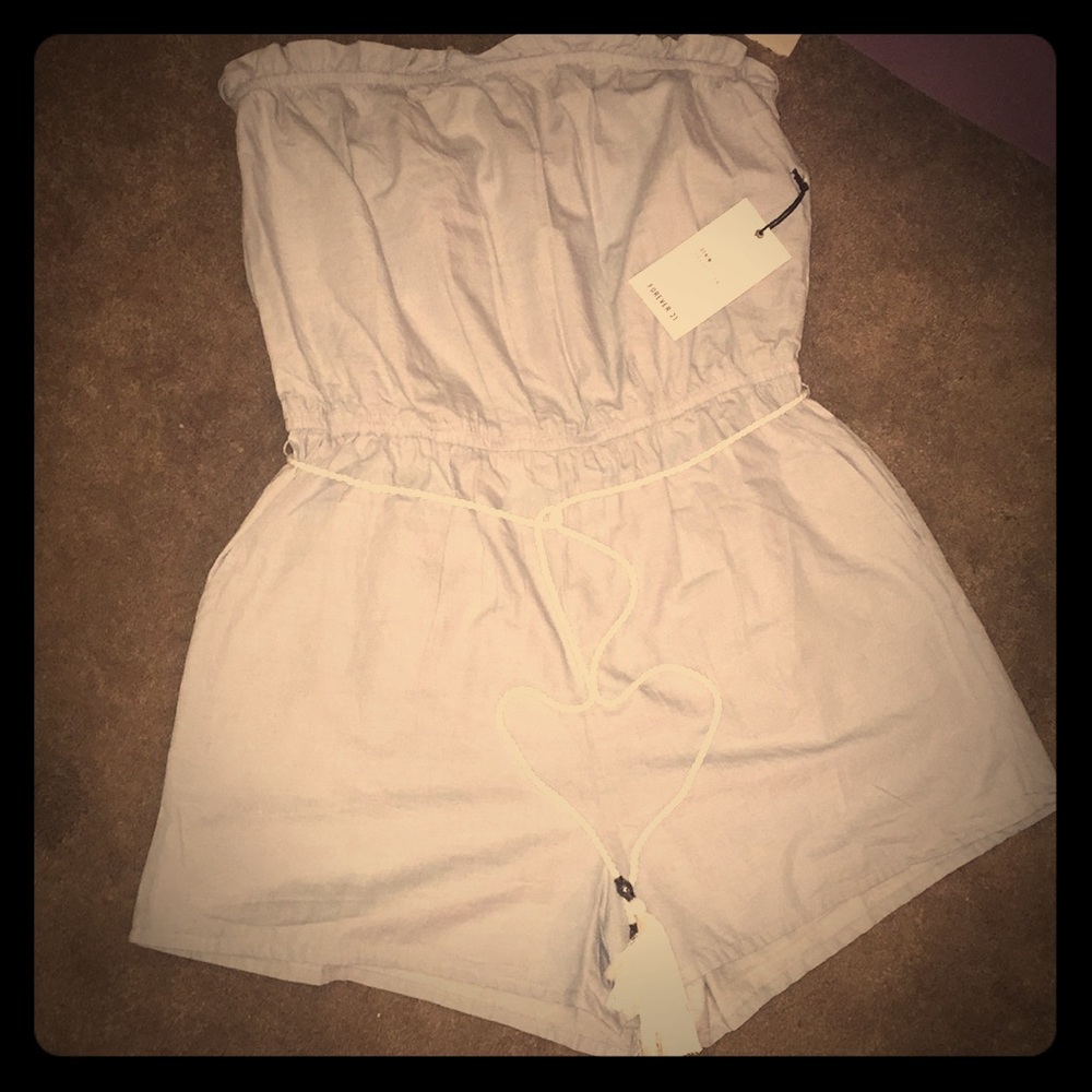 Light blue denim romper with white tassel belt